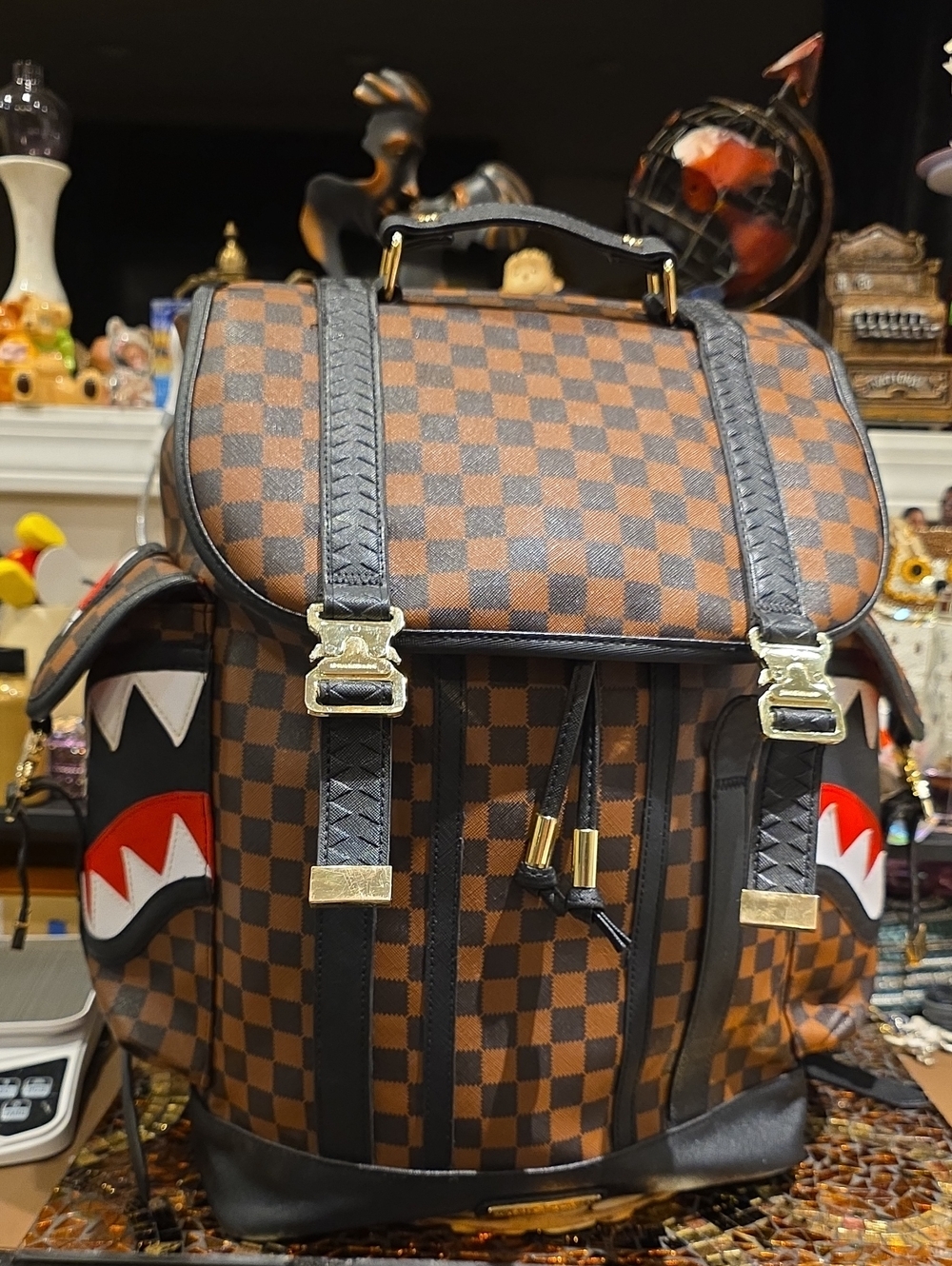 Sprayground Brown Checkerboard Backpack with Black Trim and Red Accent